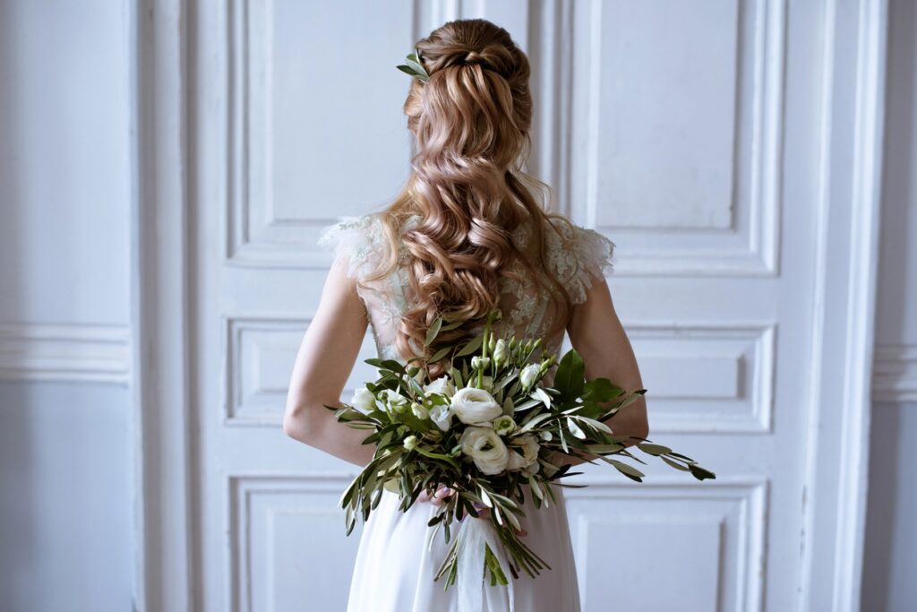 Bridal half-up, half-down hairstyle with soft curls and subtle volume, perfect for a dreamy and romantic wedding look.